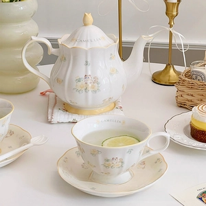 Detail of camellia ragdoll cat ceramic teapot and cup set for vintage afternoon tea time