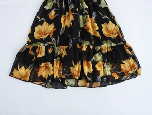 Dettaglio dell'orlo dell'abito in chiffon floreale con fiori gialli e volant a strati