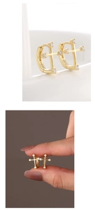 Macro detail of S925 hallmark on gold plated asymmetric cross hoop earrings with zircons