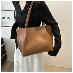 Dettaglio della borsa tote vintage in pelle PU marrone con cucitura e tracolle sottili