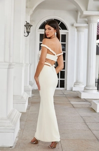 Detail view of the white evening gown showing woven shoulder straps and open back cutout
