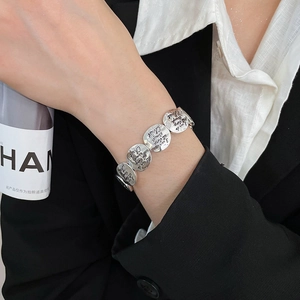 Detailed close-up of vintage silver coin bracelet with engraved inspirational scripture