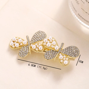 Macro detail of butterfly hair clip with pearls and rhinestones showing 6.8cm size