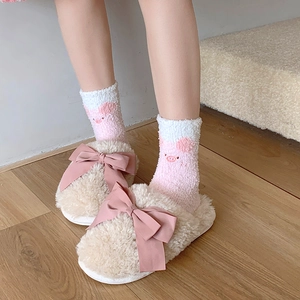 Detail of soft cream plush slippers with large pink satin bows and cozy fleece socks