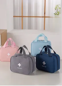Portable first aid kits in pink, gray, and blue colors with durable handles and zippers
