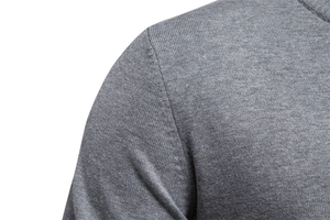 Close-up of fine grey knit texture and seamless shoulder stitching on premium sweater