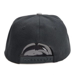 Détail de la fermeture snapback réglable en plastique noir sur une casquette hip hop à bord plat