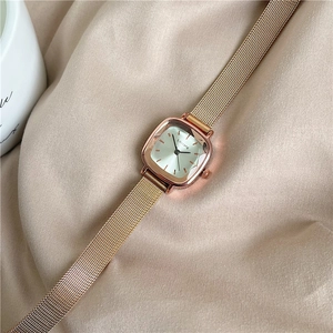 Detail shot of a rose gold square women watch with silver dial on soft fabric