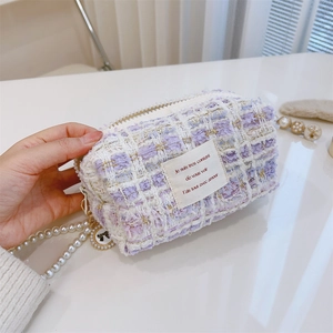 Macro detail of lavender tweed fabric with pearl chain strap and French quote label