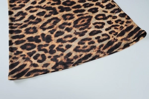 Detailed close-up of leopard print mesh skirt hem showing professional double-stitch sewing