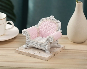 Miniature gray sofa jewelry display stand with pink upholstery and vintage carvings