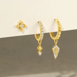 Détail d'un lot de trois boucles d'oreilles dorées avec puces étoiles et breloques zircon