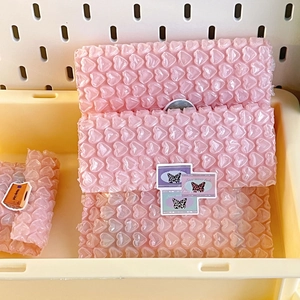 Pink heart-shaped bubble wrap sheets for gift packaging inside a cream storage box