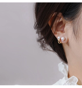 Close-up of double pearl earrings in gold finish worn by a model for an elegant look