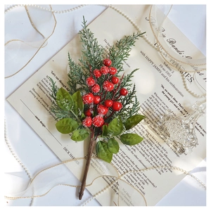 Close-up of artificial red berry and pine branch with snow effect on vintage paper