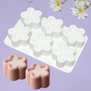 Macro shot of 6-cavity white silicone mold with finished flower and star mousse cakes