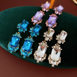 Detailed macro view of vintage geometric gold earrings with purple, blue and white crystals