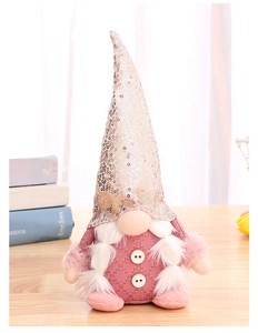Detail of pink gnome plush with sequined hat and soft white beard on a wooden table