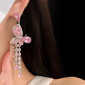 Macro shot of pink butterfly long tassel earrings with sparkling zircon on model