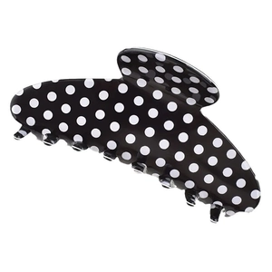 Detail shot of a black and white polka dot hair claw clip with smooth plastic finish