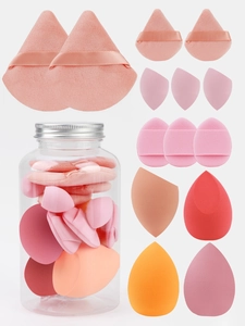 Macro view of multi-shaped makeup sponges including teardrop and slanted cut puffs in a jar