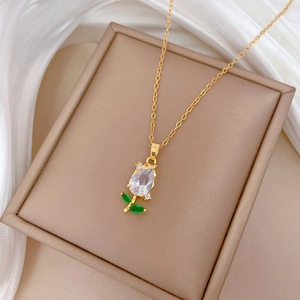 Detail of gold tulip pendant necklace with sparkling white and green crystals on silk