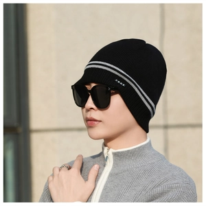 Detailed close-up of a black knit beanie featuring grey stripes and textured wool material