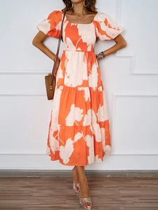 Détail des manches bouffantes et de l'imprimé floral orange sur une robe d'été