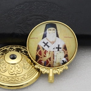 Detail view of gold Orthodox icon with St. Nectarios and its decorative metal base stand