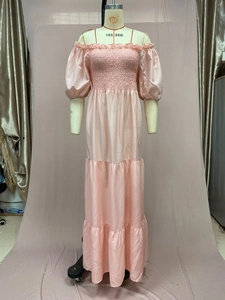 Detail of light pink tiered maxi dress with smocked bodice and off-shoulder puff sleeves