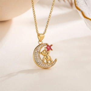 Macro detail of gold bear pendant with crystal crescent moon and pink star gem