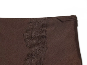 Détail macro du satin marron foncé avec bordure en dentelle noire et fermeture éclair