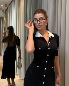 Detail showing contrast doll collar and white buttons on a black slim knit dress