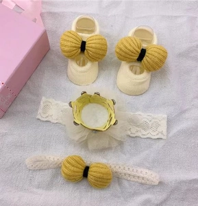 Detail of infant gift set with yellow knit bow socks and lace crown headbands