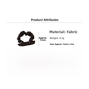 Detailed view of black polka dot fabric hair scrunchie with dimensions 7.2cm by 7cm