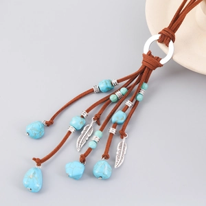 Detailed macro view of bohemian turquoise stone pendant with silver feather charms
