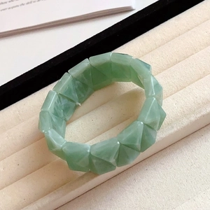 Close-up of light green geometric faceted beads on a vintage elastic acrylic bracelet
