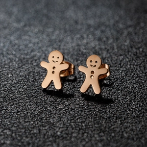 Golden gingerbread man stud earrings for women on a textured black background