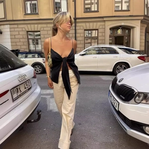 French retro backless camisole with bow tie detail and white pants in urban street style