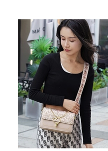 Detail of beige flap bag featuring star-dust gold sequins and heart-shaped metal buckle
