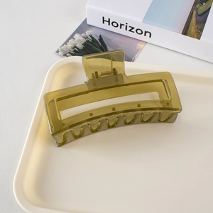 Macro detail of a 13cm olive green shark hair clip on a minimalist tray for thick hair