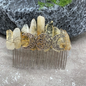 Detail of handmade natural yellow crystal hair comb with silver Triple Moon goddess symbol