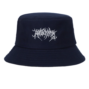 Close-up of white Gothic embroidery on a vintage washed dark blue cotton bucket hat