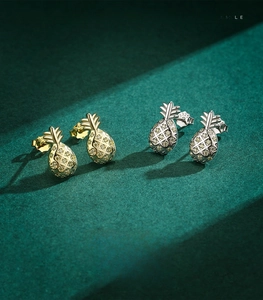 Vue macro de boucles d'oreilles ananas en argent S925 serties de pierres jaunes fines