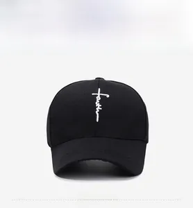 Front view of black cotton baseball cap with white embroidered faith cross design