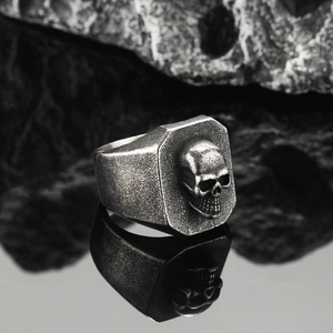 Vintage gothic skull ring for men in antique silver finish on black rock background