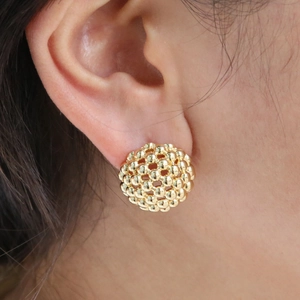 Detail of 18K gold beaded spherical stud earring showing intricate mesh hollow structure