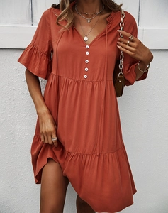 Détail de la robe terracotta avec décolleté en V, boutons décoratifs et manches à volants