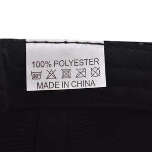 Close-up of internal wash care label showing 100% polyester content on black plaid cap
