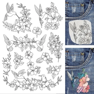 Detail of hummingbird and hibiscus embroidery stabilizer on denim pocket and final stitching
